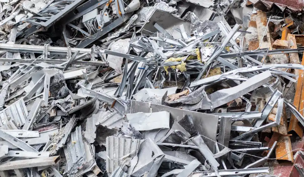 Pile of aluminum and non-ferrous metal scrap pieces stacked in a recycling yard.